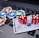 A set of red dice and poker chips are placed on top of a credit card, which is situated on a laptop keyboard. The poker chips are in various colors, including blue, green, red, and white.